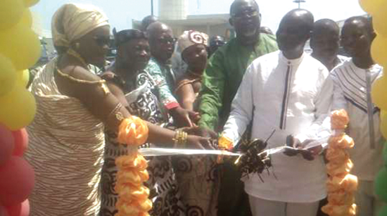 Mr Ekwow Spio-Garbrah (in green) being assisted by other diginitaries to cut the tape to open the fair